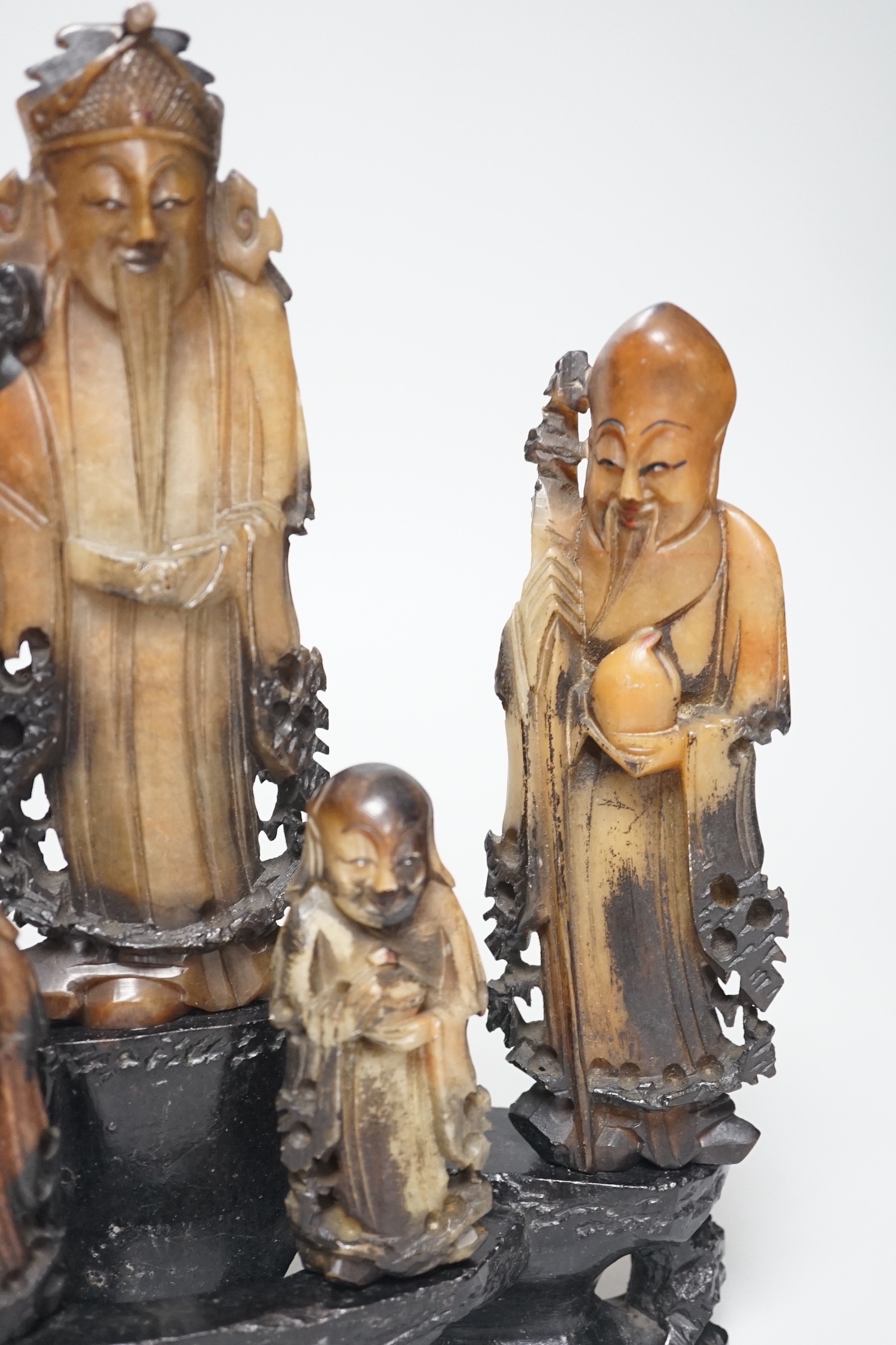 An early 20th century Chinese carved soapstone group of five deities on a rockwork base, 23cm